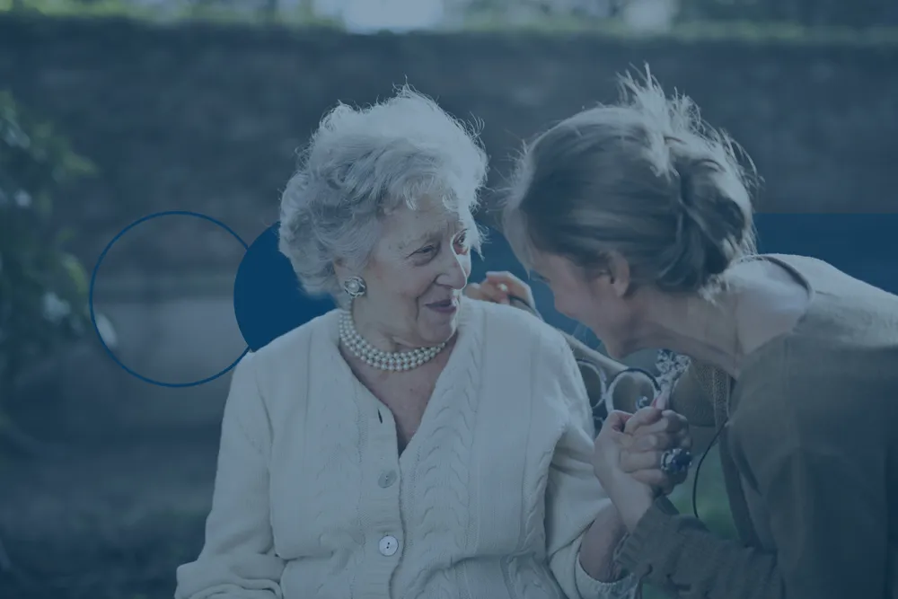 Grandmother and granddaughter sitting and talking in a park